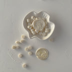 White ceramic dish with small white objects on a gray surface