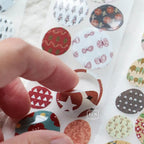 Close-up of round patterned stickers featuring flowers, trees, and abstract designs in muted earthy colors.