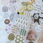 Hand peeling a circular washi sticker from PET tape sheet showing adhesive quality and smooth finish.