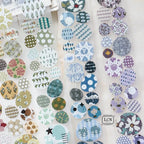 Variety of round decorative stickers with vintage, botanical, and geometric prints arranged on a sheet for journaling.