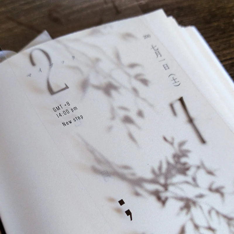 Stack of white cards with black text and minimal design on a wooden surface