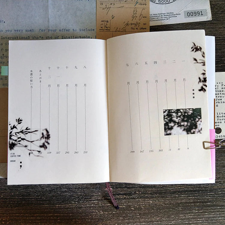 Open book with printed text and images on a wooden surface