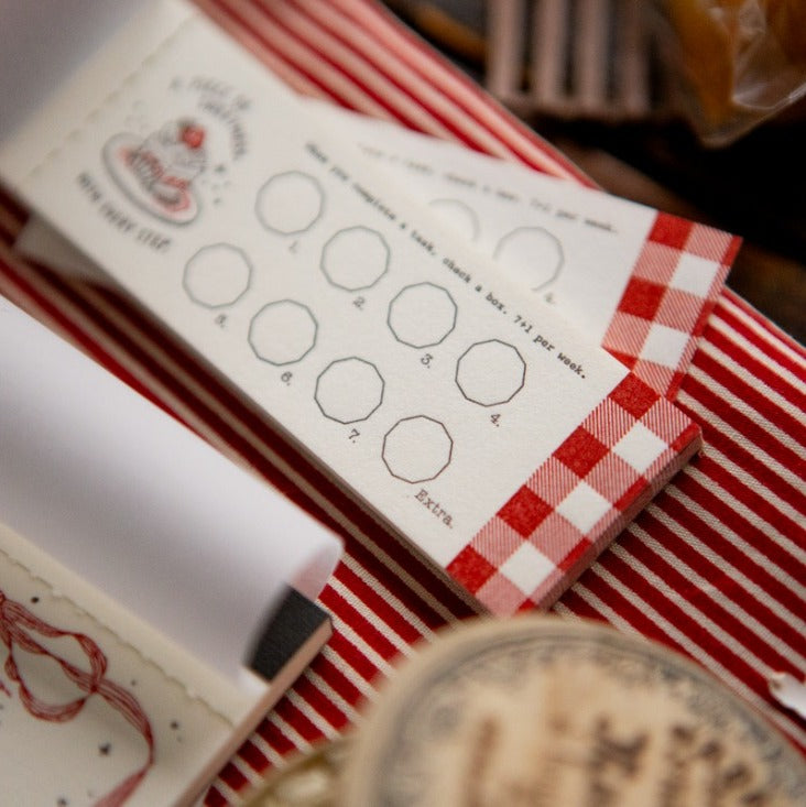 Red and white checkered box with a printed form on top, blurred background