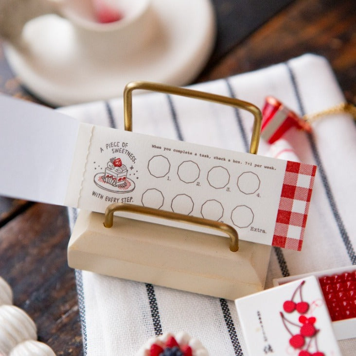 Piece of Sweetness Letterpress sheet in a wooden card holder on striped fabric, detail view