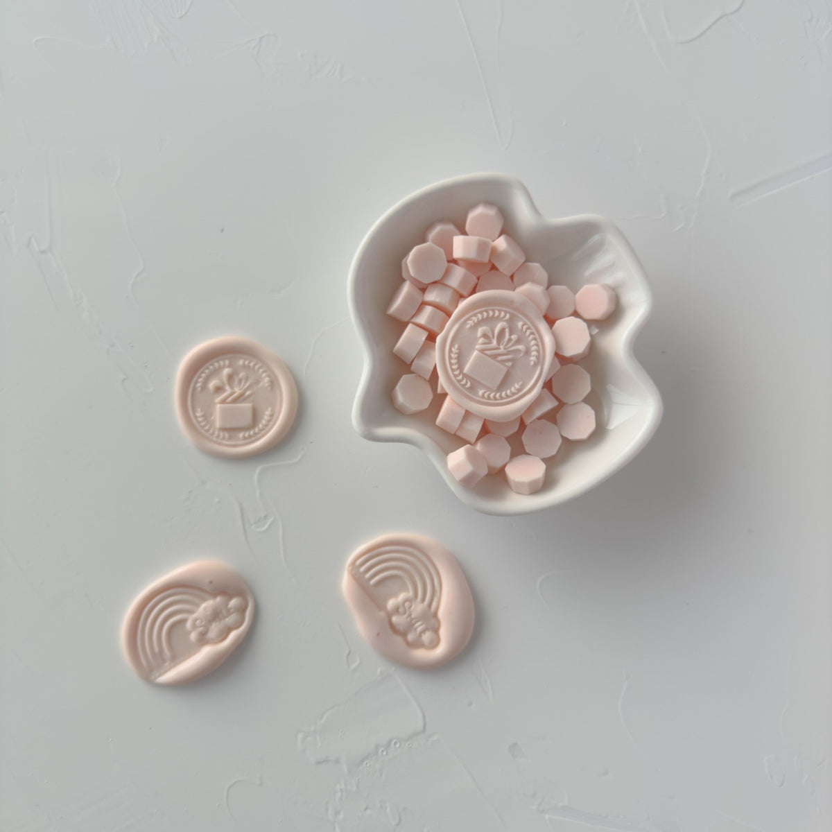 Stamped Pink Flamingo wax seal with decorative impressions, close-up detail on a soft grey background