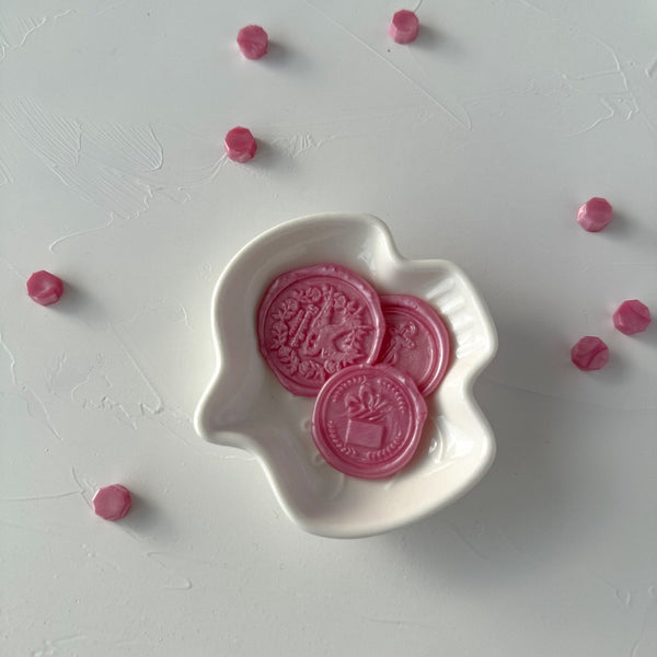 Pink Pearl Wax Beads with a stamped pearly pink wax seal displayed in a white dish on a light grey background