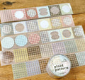 Set of plaid patterned washi tape rolls on a wooden surface