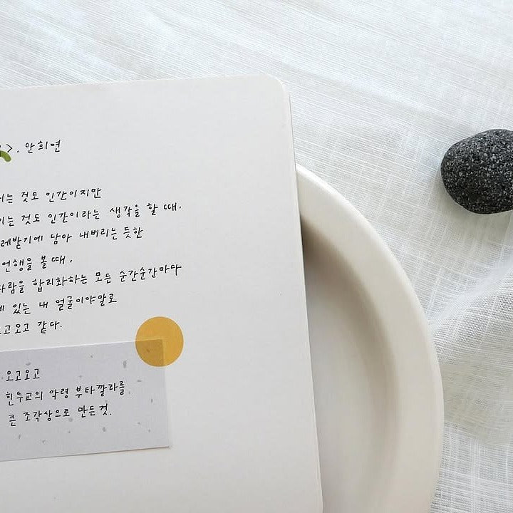 Notebook with handwritten text beside a stone, from the Plain 66 Sticker Sheet
