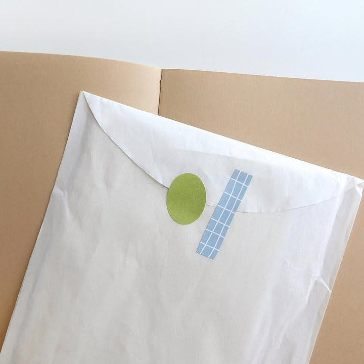 White pillow with a green circle and blue checkered pattern, from the Plain 66 Sticker Sheet