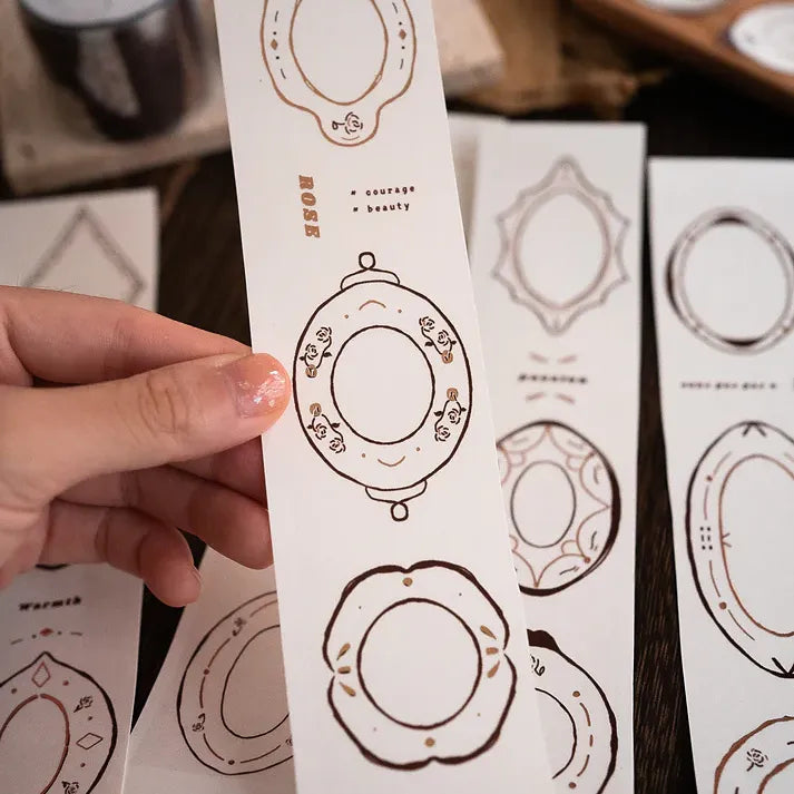 Hand holding a sheet of intricate die-cut Plates Rose Gold PET Tape plate designs, close-up detail