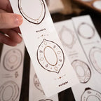 Card with geometric design and text held by a hand, with more cards in the background.