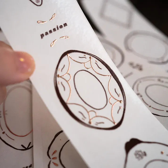 Hand holding a card decorated with Plates Rose Gold PET Tape and the word passion in elegant script
