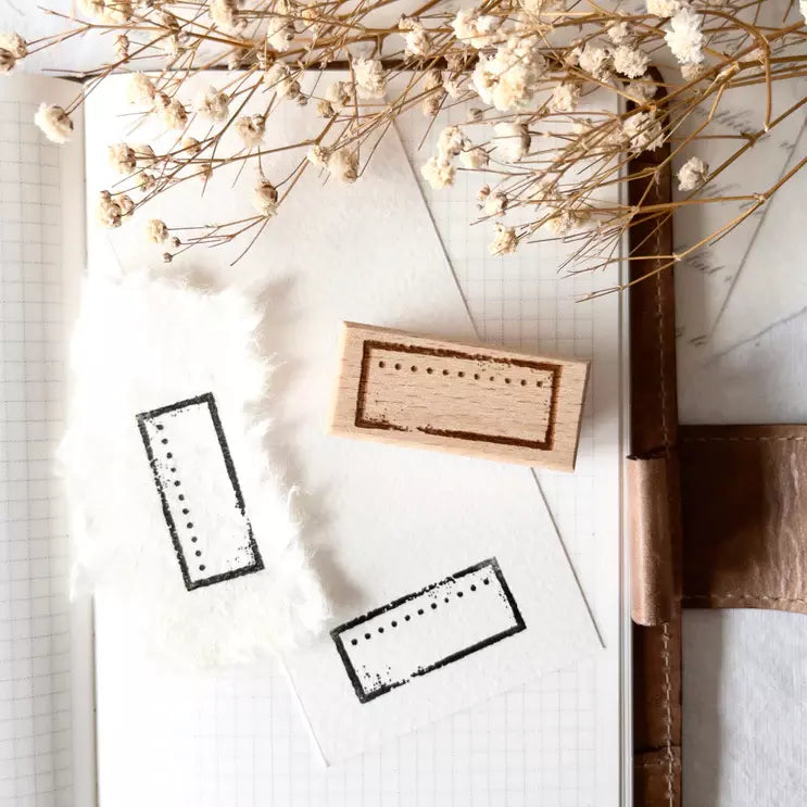 Postal Frame Rubber Stamp with two frame impressions on a notebook page with dried flowers