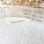 Vintage-style postage stamps on a white fabric background with dried flowers.