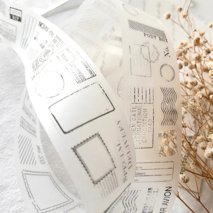 Posted PET Tape stamp motifs with ornate vintage detailing styled beside dried flowers, close-up