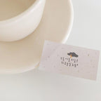 Small rectangular paper with text and a design on a light background