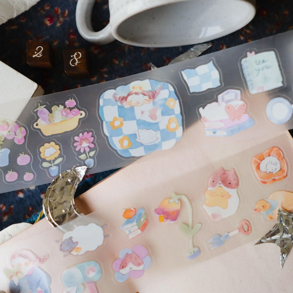 Colorful temporary tattoos on a person's arm with a cup and other items in the background.
