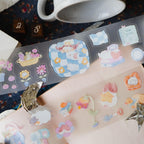 Colorful temporary tattoos on a person's arm with a cup and other items in the background.