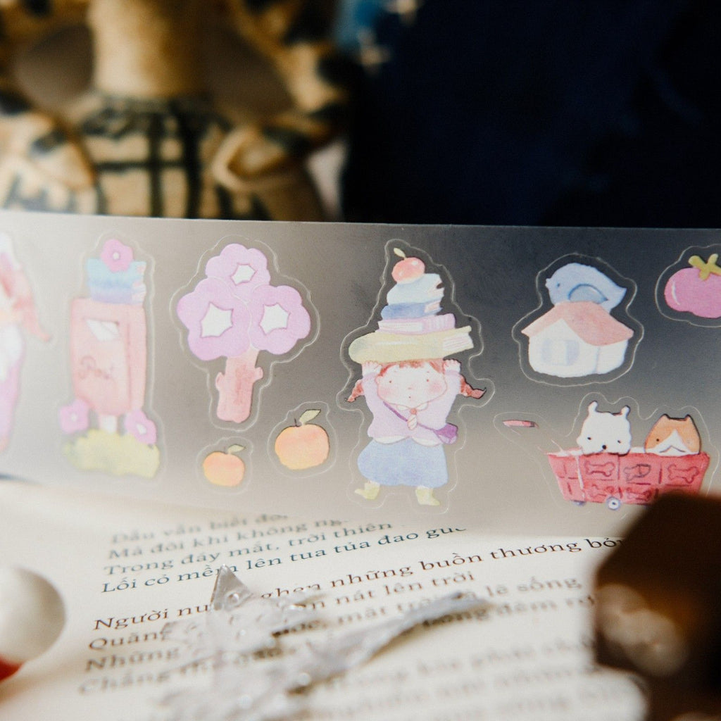 Sheet of colorful stickers featuring cartoon characters and objects on a book page.