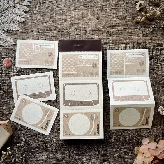 Set of cassette tape-themed stickers on a textured surface with decorative elements.