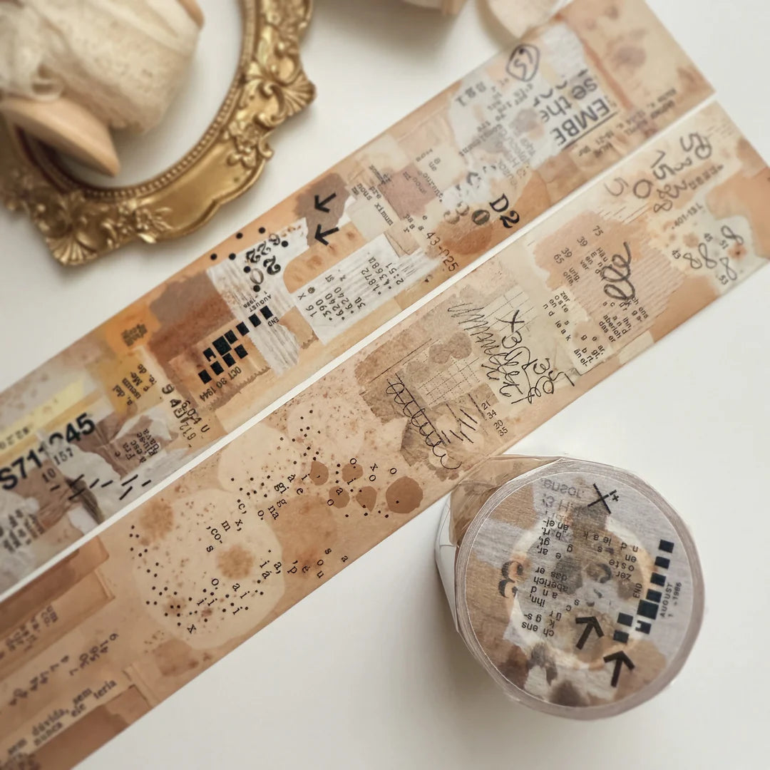 Strip of Remind Washi Tape with text and patterns applied on a white surface, close-up