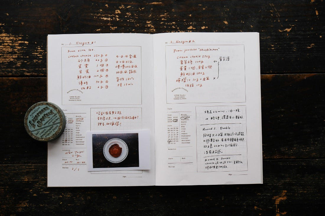 Open Research Notes Notebook with text entries and a small round object on a wooden surface