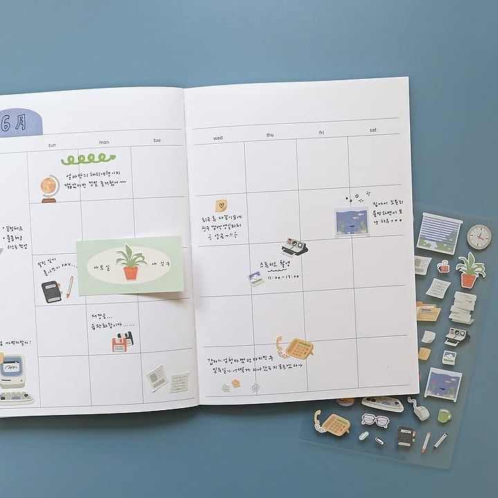 Open planner with stickers on a blue background, from the Retro Office Sticker Sheet