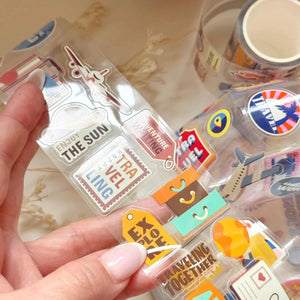 Hand holding the packaged Retro Travel Airline Stamps PET Tape by Kolour Cafe, front view