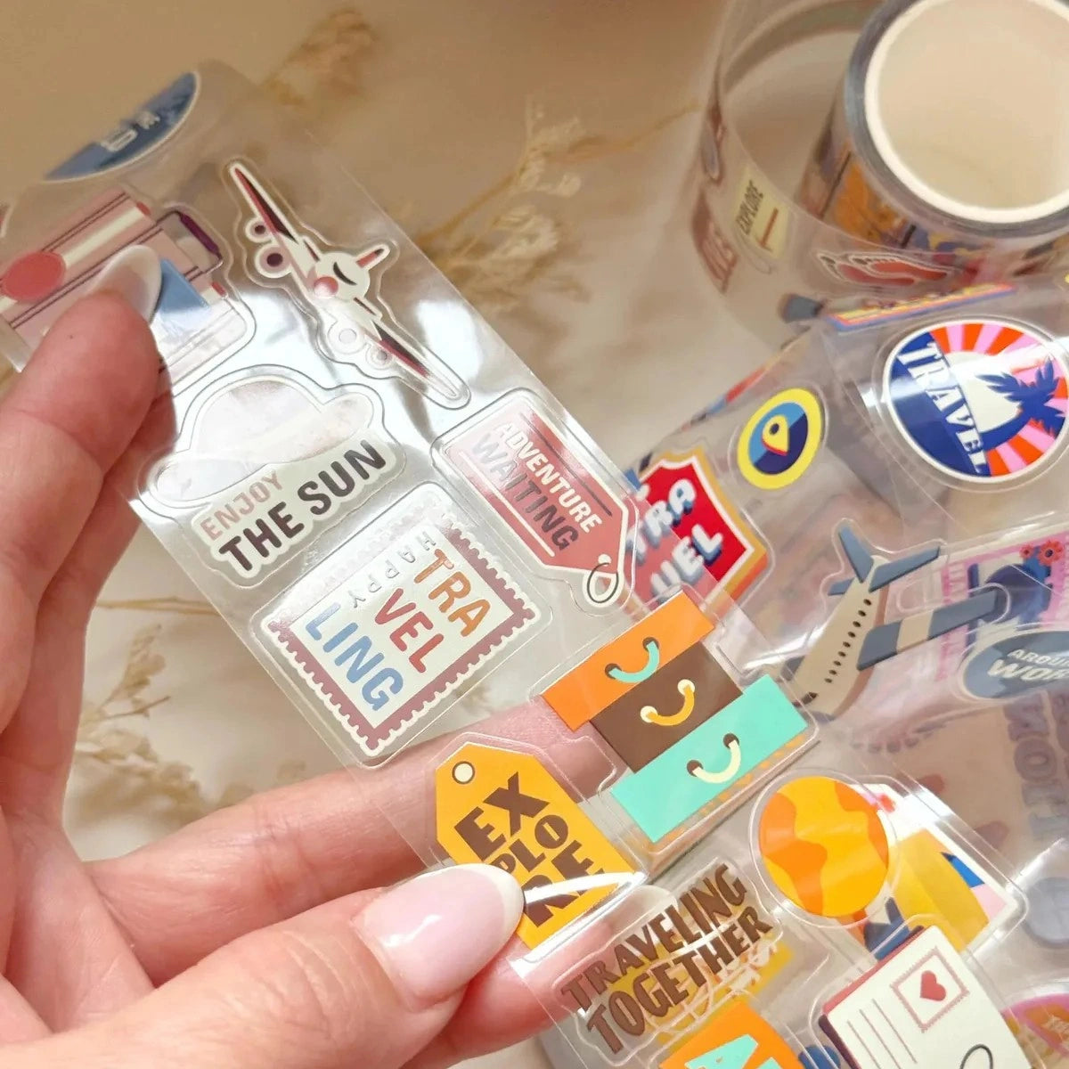 Packaged travel-themed stickers with a hand holding the packaging.