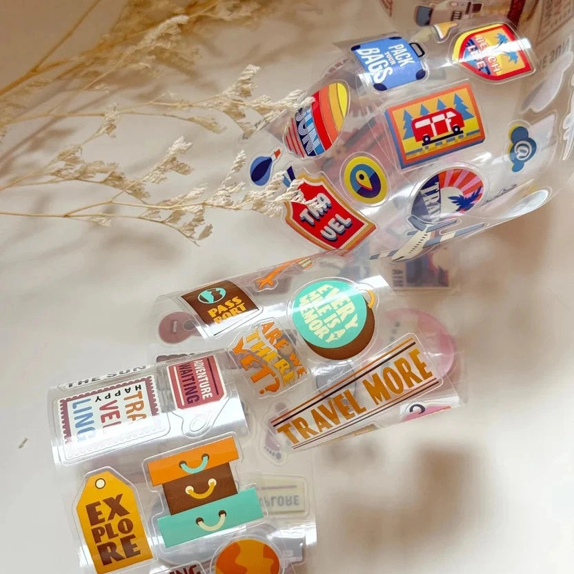 Colorful travel-themed decorative stickers on a light background