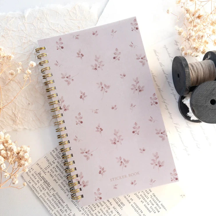 Floral-covered Reusable Sticker Storage Book open to its release paper pages on light