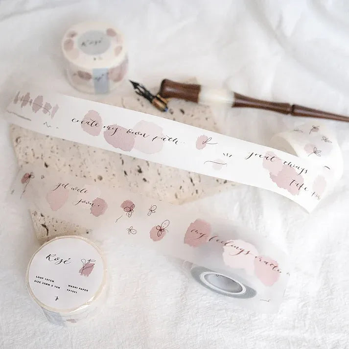 Rose Calligraphy Spiritual Quote PET Tape with pink florals and script laid out on a white surface