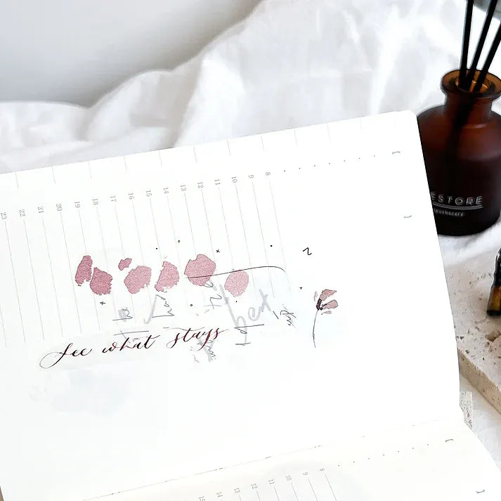 Rose Calligraphy PET Tape floral notebook scene with a reed diffuser in the softly blurred background
