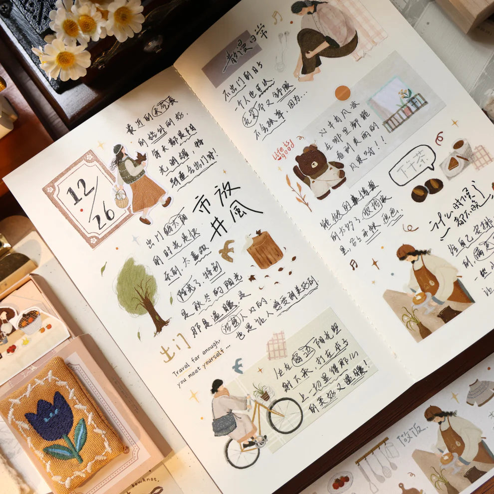 Open book decorated with Salty Lifestyle PET Tape illustrations and text on a wooden desk
