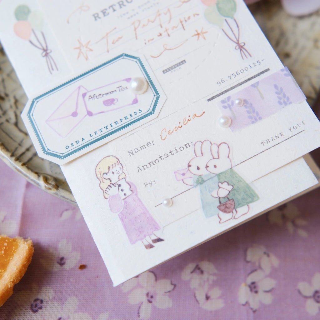Children's party invitation card with illustrations of a girl and a rabbit on a floral tablecloth.
