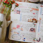 Open notebook with colorful stickers and text on a patterned surface