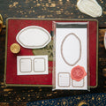 Decorative stationery set with stamps and seals on a rustic wooden surface.
