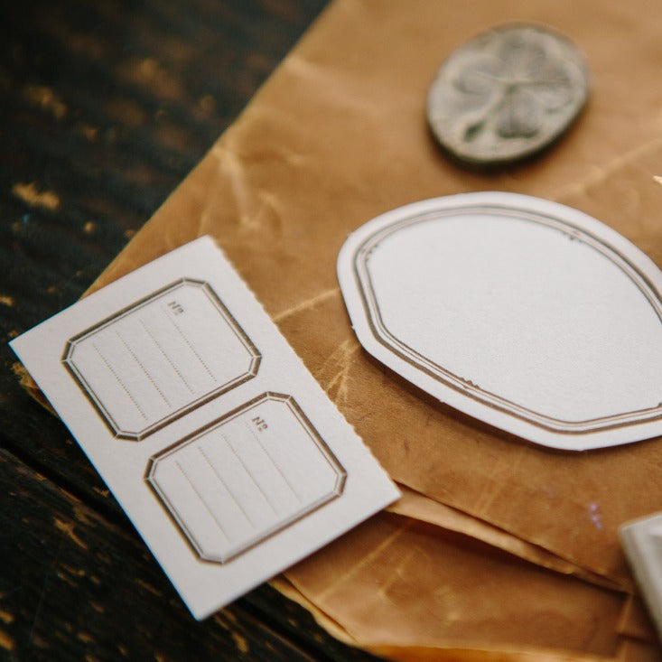 Shell Label Letterpress Memo Pad scallop labels on brown paper beside a fountain pen