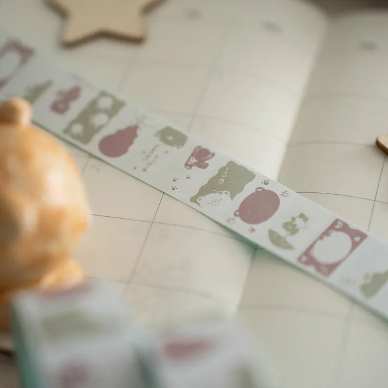 Book decorated with Kuma Label Sticker Tape bear stickers styled on a tiled floor