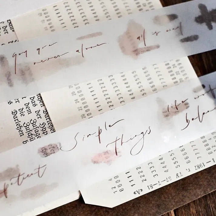 Translucent Simple Things PET Tape sheets with florals and text arranged on a wooden surface
