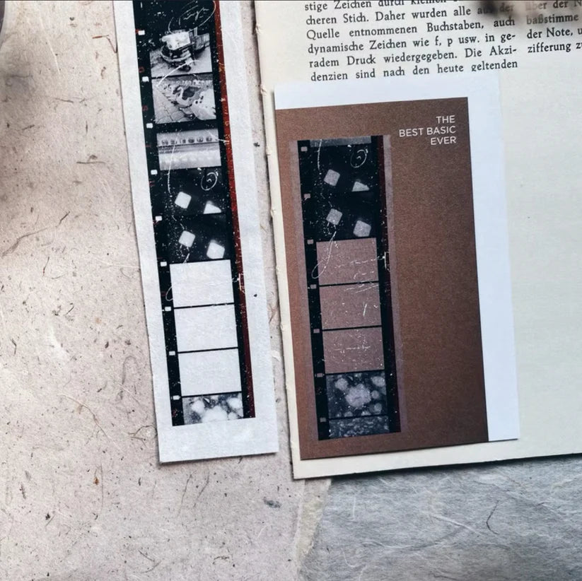 Skyline PET Tape paper pieces with text and a film strip design on a textured surface