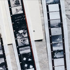 Close-up of vintage film negatives and prints on a textured surface