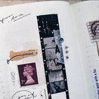 Open book with decorative elements like stamps and film strip