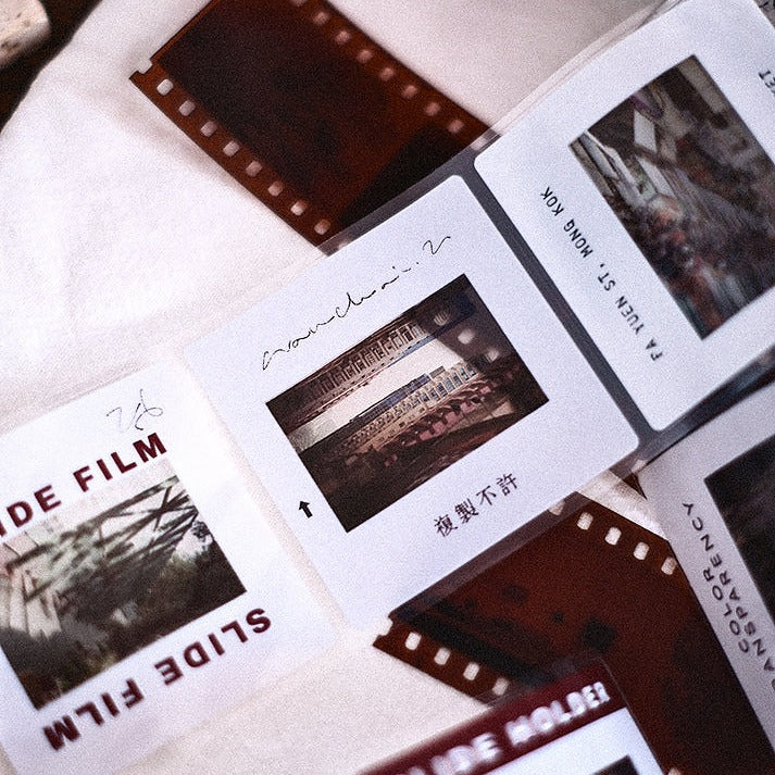 Slide Film PET Tape negatives with printed text and images laid out on a textured craft surface