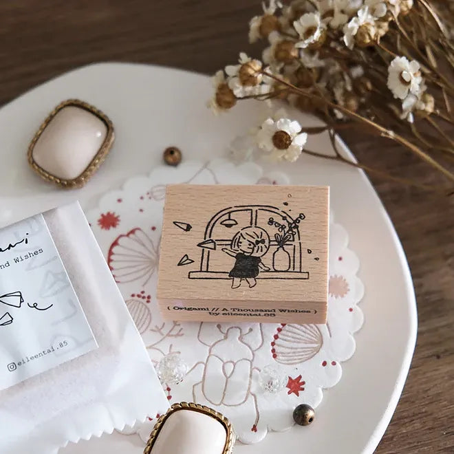 Wooden stamp with design on a decorative plate with flowers and jewelry