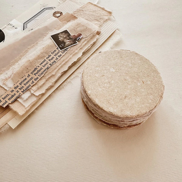 Stack of Small Circle Handmade Paper rounds styled with vintage paper and a stamp