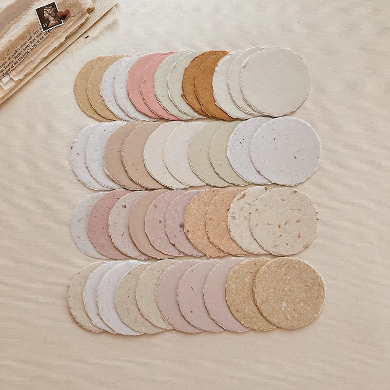 Small Circle Handmade Paper rounds in soft beige tones on a light surface, styled detail view