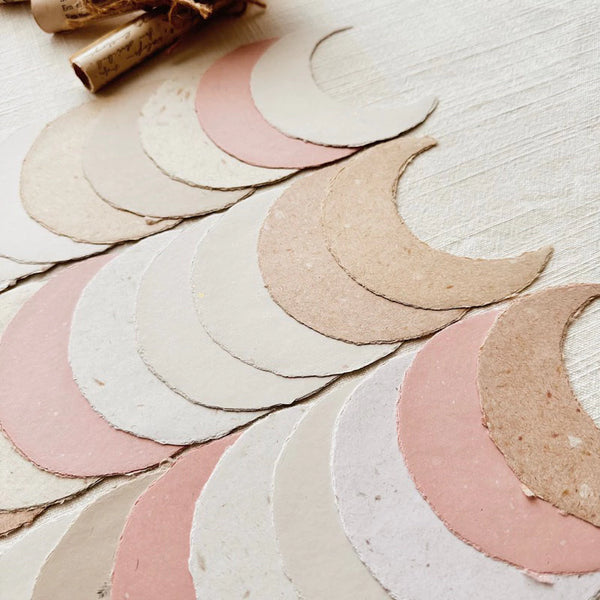 Small Moon Handmade Paper crescent cutouts in mixed colors on a light wooden surface