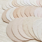 Set of round, beige-colored coasters on a textured surface