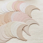Set of crescent-shaped objects in various pastel colors on a textured beige background